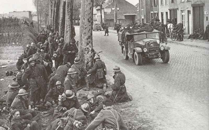 Belgian soldiers take a rest by the roadside