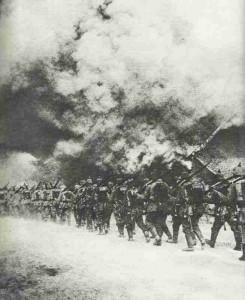 German infantry marching through a burning village in northern France