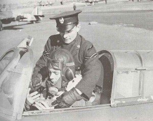 Polish pilot is helped into his plane by a Polish Air Force corporal