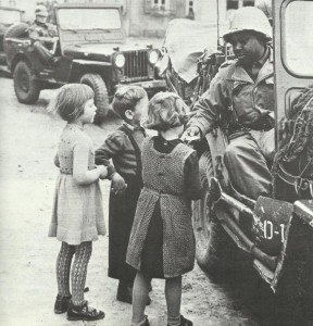 black US soldier gives off sweets to children