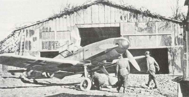 e 109 F is standing outside a hangarette camouflaged as a barn