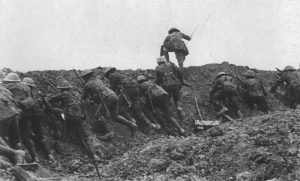 An officer is leading a section of British infantry out of a trench