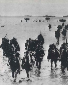 Japanese troops walk ashore. 