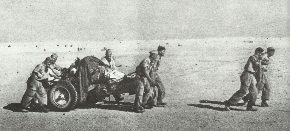 German paratroopers pull gun through the desert