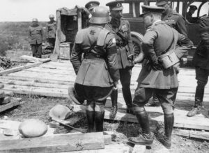ritish staff officer demonstrates a German helmet and trench armour 