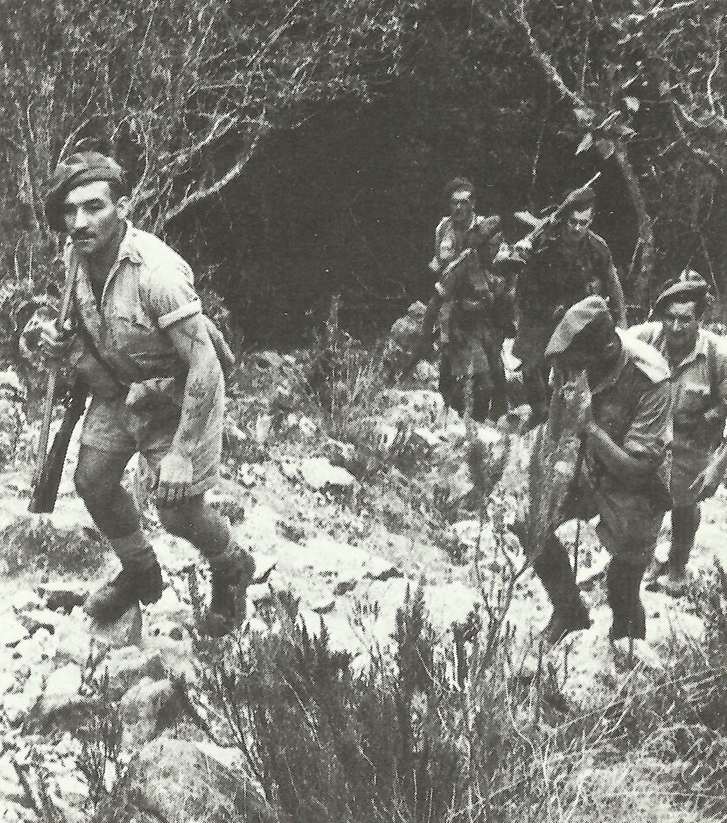 British soldiers trudge up a rocky hillside